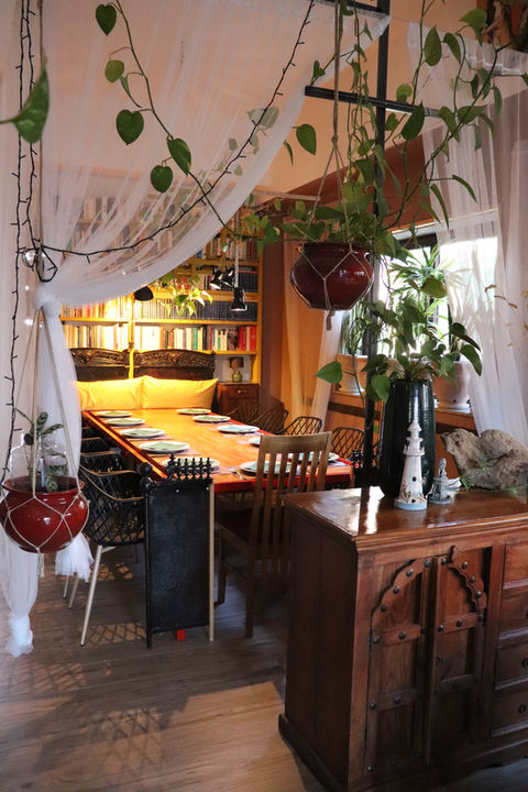 Tavolo apparecchiato in sala da pranzo con piante rampicanti