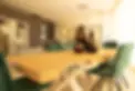 Sala riunioni moderna con tavolo in legno e sedie verdi