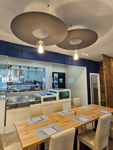 Interno di un ristorante con tavoli in legno e lampade moderne