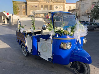 Ape Piaggio blu e bianca decorata con fiori per matrimonio.