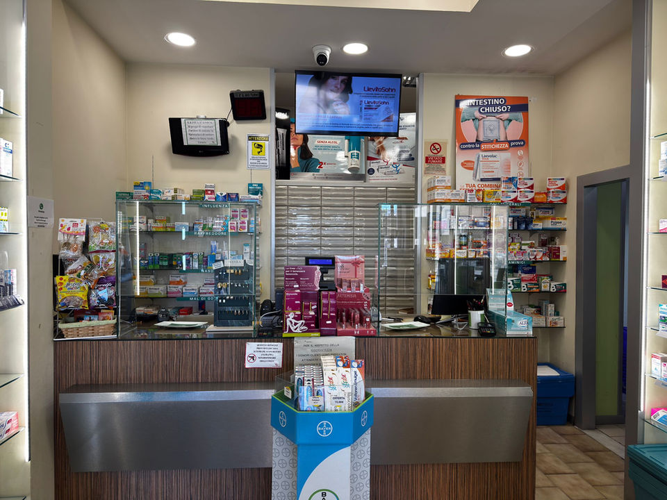 Bancone di una farmacia moderna con schermi e scaffali