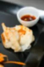 Gyoza dorati con salsa di accompagnamento da Yaimai Thai Restaurant