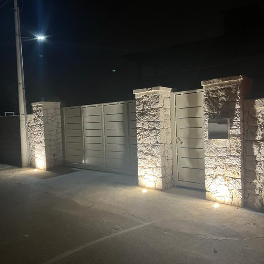 Muro di cinta in pietra illuminato di notte
