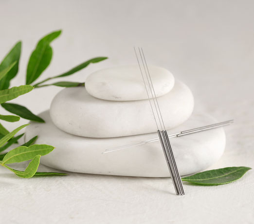 Acupuncture needles and spa stones on light background.jpg
