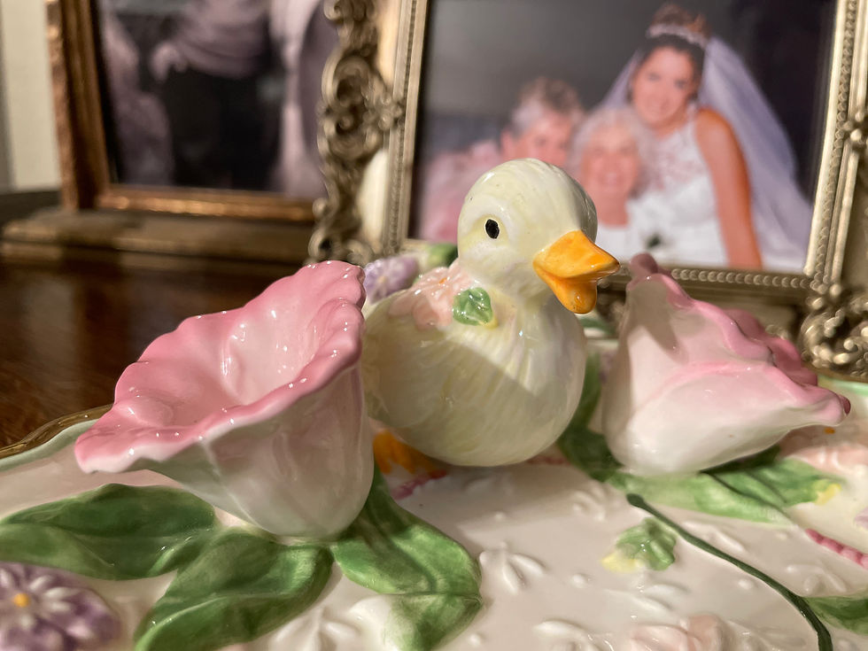 Close up of "Darlin' Daisy" on the Easter tray and nestled in between two purple flowers