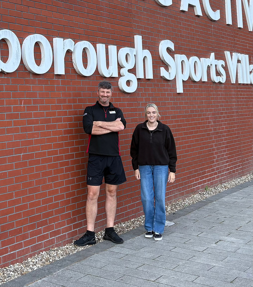 a man and a woman standing in front of scarborough sports village