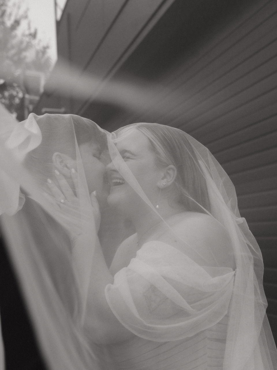 couples playfully kissing under the veil in a fall wedding in Portland Oregon