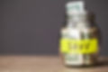 dollar-bills-in-glass-jar-on-wooden-table-2023-11-27-04-54-14-utc.jpg