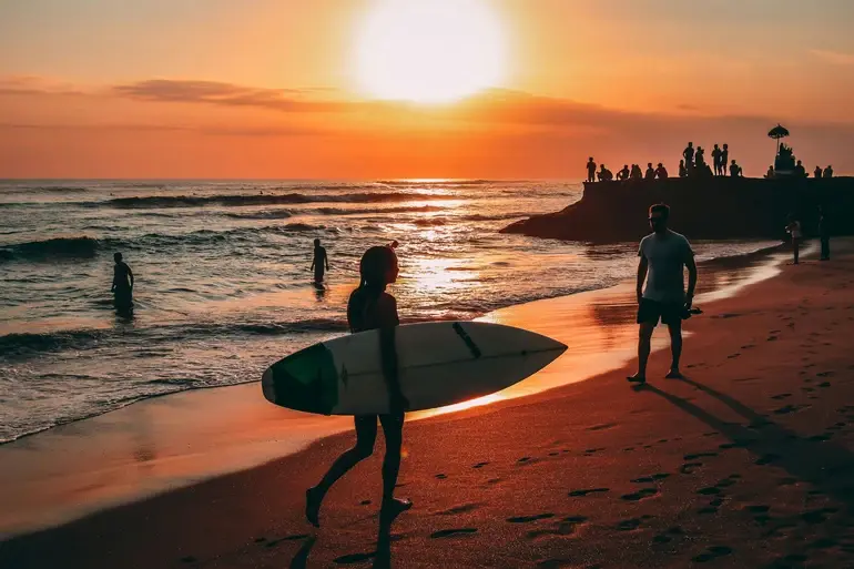 Surfers off a Canggu beach in Bali  -  the kind of scene creators come to film, and the area the 2026 immigration task force patrols most