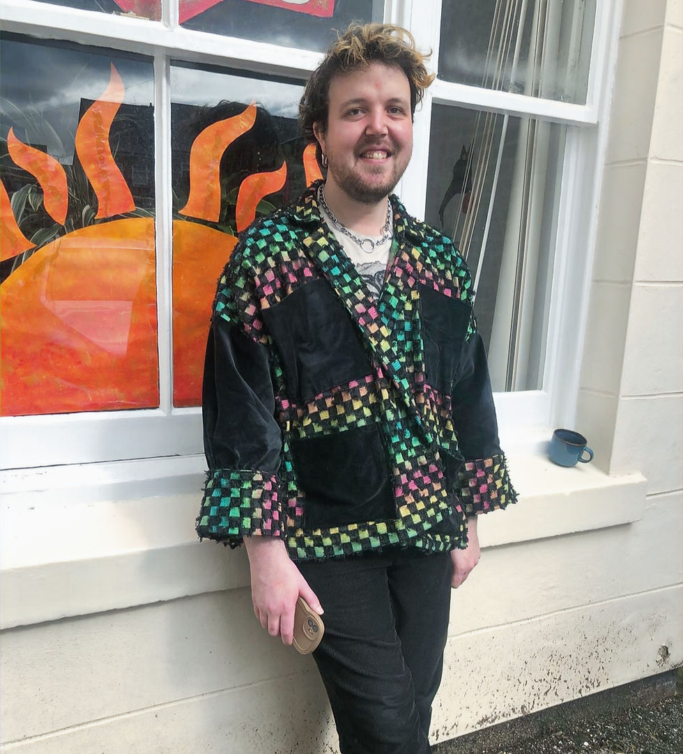 Me wearing the checkered jacket leaning against a wall, smiling. A painted sun is on the window behind them. Mood is cheerful.