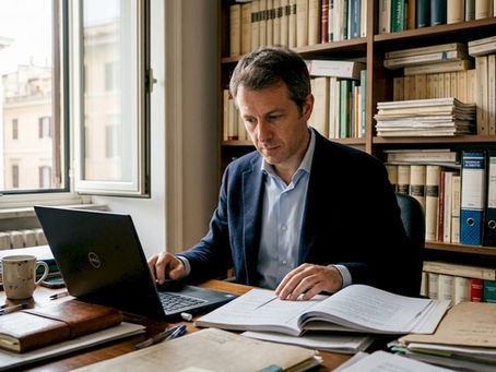 Un avvocato esamina dei fascicoli nel proprio studio legale.