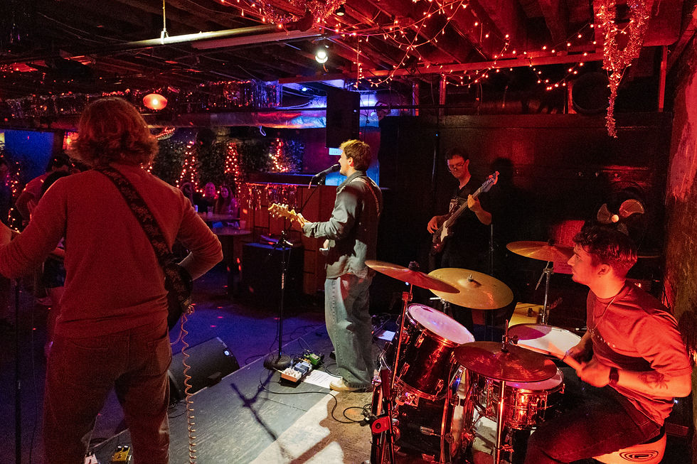Eye-level view of Flatrock performing on stage at Neptunes Parlour with warm lighting and intimate crowd