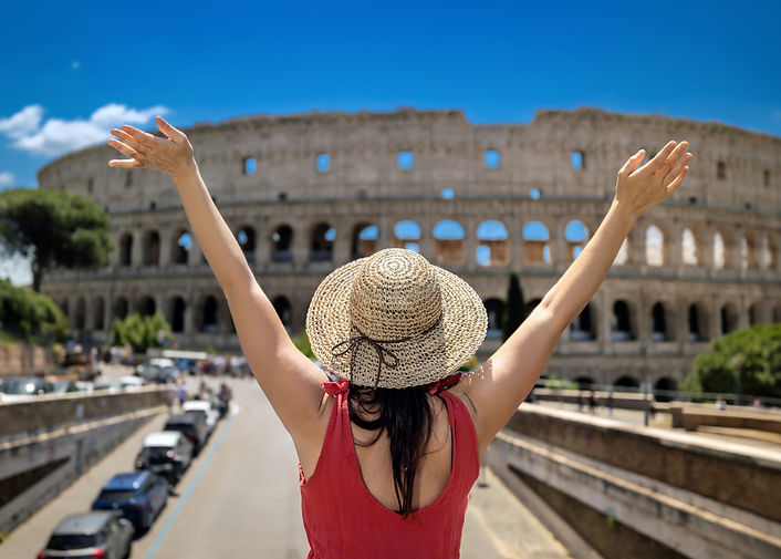A girl in straw hat on a tourist visit to Rome in Italy, rejoices and raises her arms in f