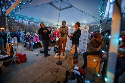 Lagomorph Quartet performs with fiddles under an illuminated tent.