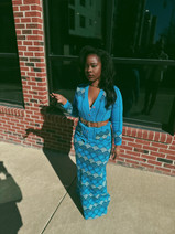Full-length shot of Mrs. VP in vintage blue scalloped pattern dress and statement belt, showcasing the flowing silhouette