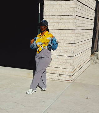 Side profile of Mrs. VP showing the perfect blend of '90s style - yellow fish print shirt layered under a cropped blue jean jacket with grey trousers