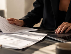 Boekhouder controleert financiële documenten en administratie naast een laptop