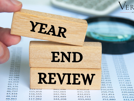 Hand met blokken ‘Year End Review’ naast cijfers en vergrootglas – boekhouder Naarden Bussum helpt ondernemers met financiële checklist 2025