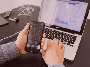 Ondernemer bekijkt beursgrafieken op laptop over zakelijk of privé beleggen in 2026