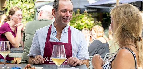 Chef en gast bij een wijntafel tijdens Druif in de Stadstuin Hilversum