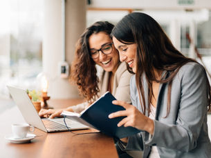 Sollicitatiegesprek tussen twee dames in modern kantoor, passend bij eerste medewerker aannemen – tips van boekhouder Naarden.
