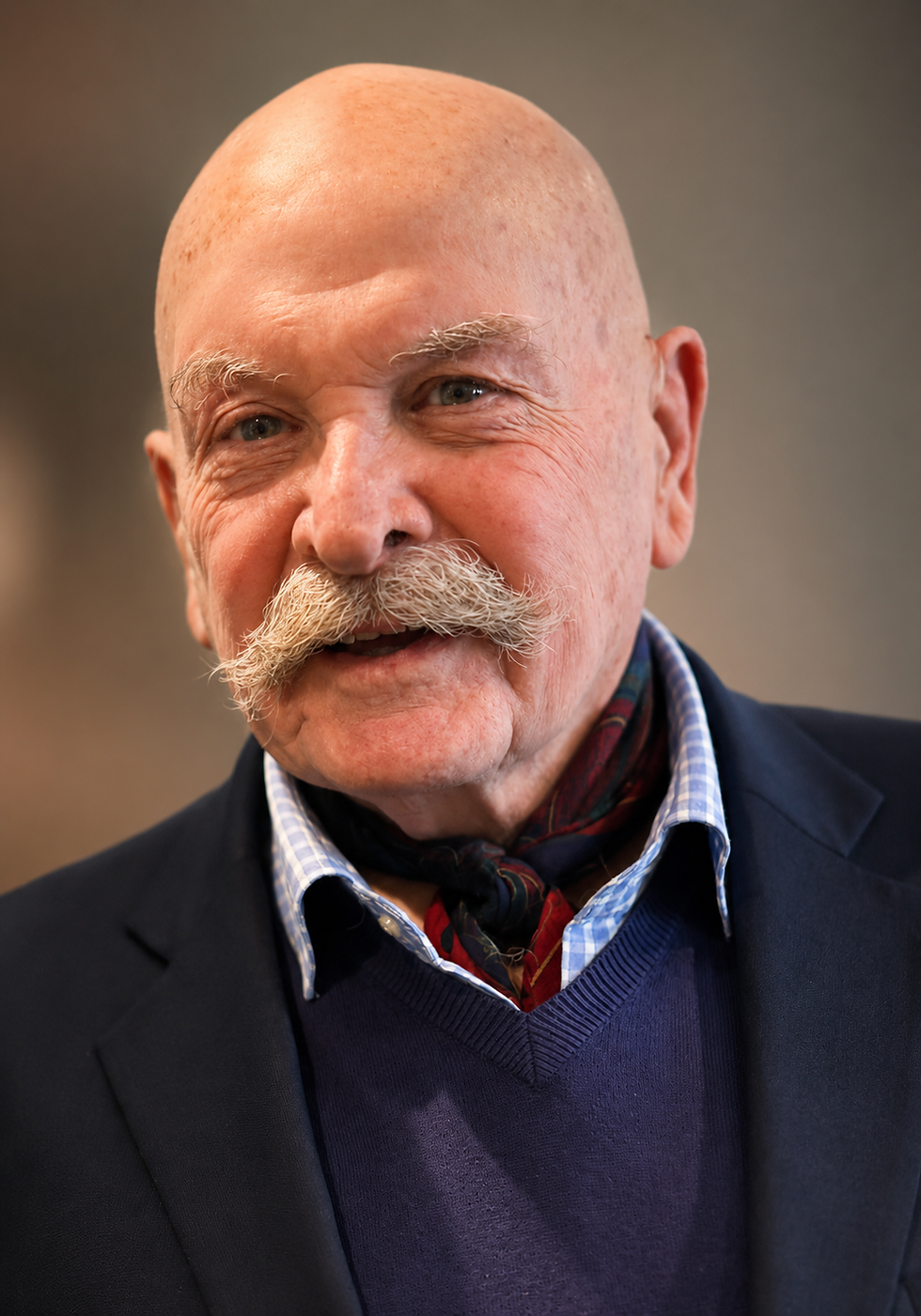 Portrait headshot of Russell W. Brothers Jr., smiling, in a blazer and sweater, centered, portrait orientation.