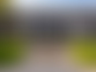 Two-story concrete testing center building with dark tinted windows and central stairs leading to the entrance.