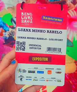 Crachá de escritora contra um fundo de colagem em evento literário..