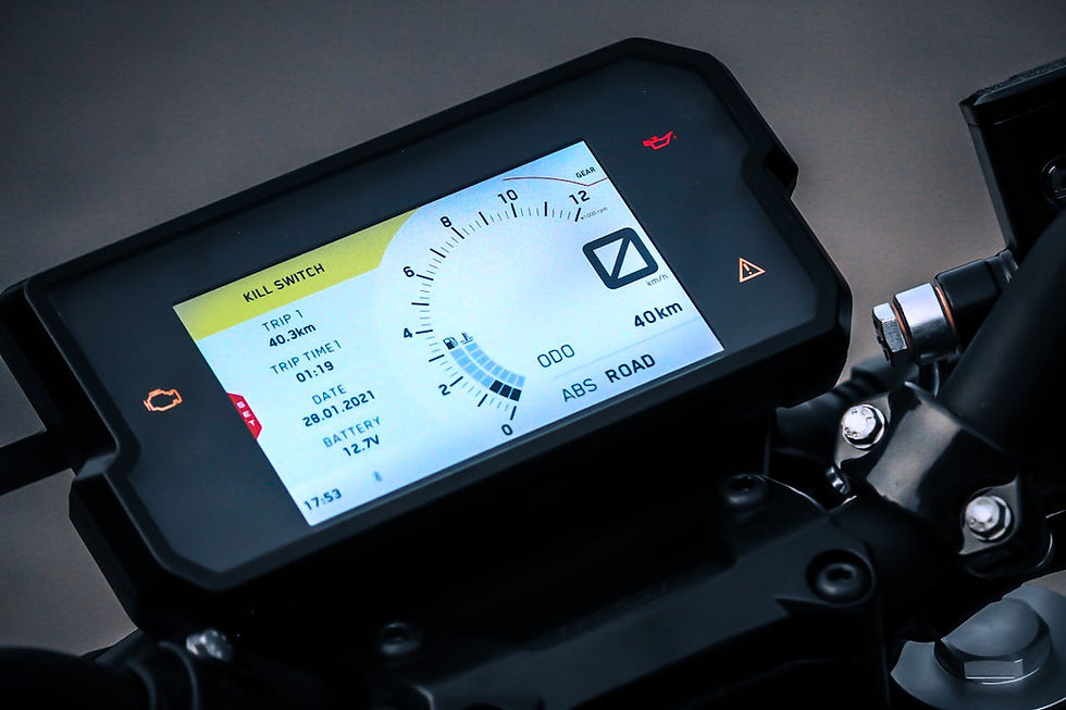 Motorcycle digital dashboard displaying trip info, battery level, and speed gauge. Colors: black frame, bright screen.