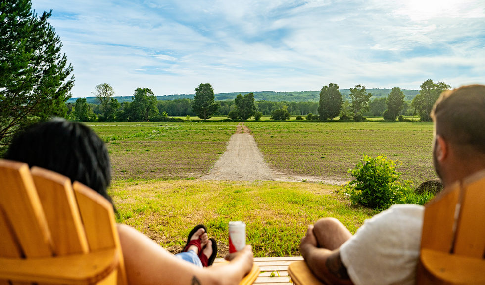 A couple relaxing and enjoying the breath taking views from our custom built patio outside the barn at Boho Beaver.