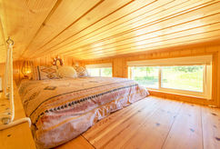 A loft sleeping area fitted with a premium queen-size bed for two.