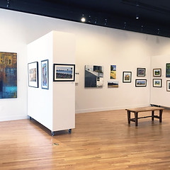 Interior photo of LowellArts featuring artwork hanging on white walls