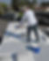 Faded background of man rolling rubberized coating onto RV roof