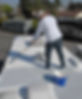 Faded background of man rolling rubberized coating onto RV roof