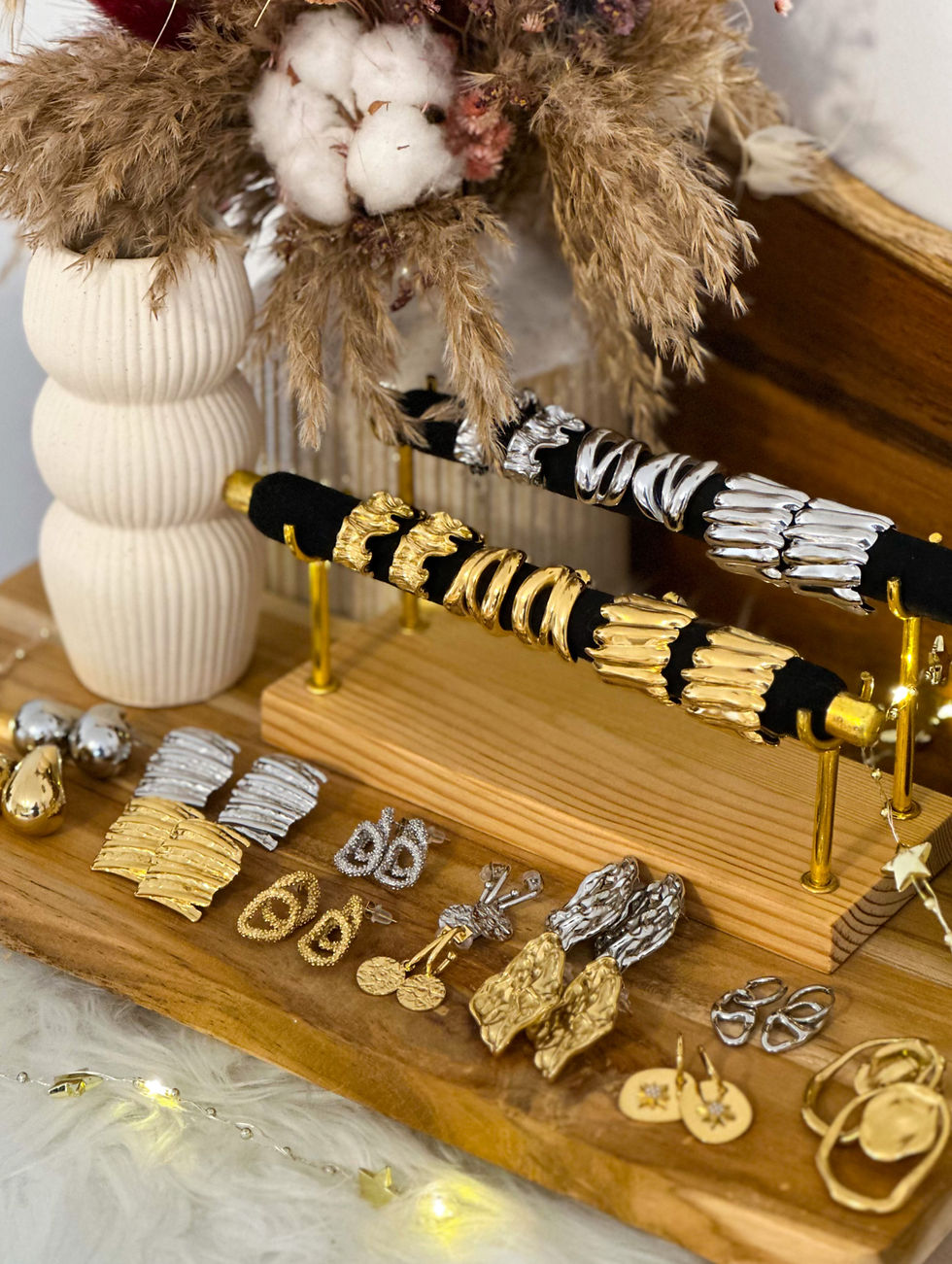 Miniature : Collection de bijoux dorés et argentés, stylos décoratifs sur planche en bois.