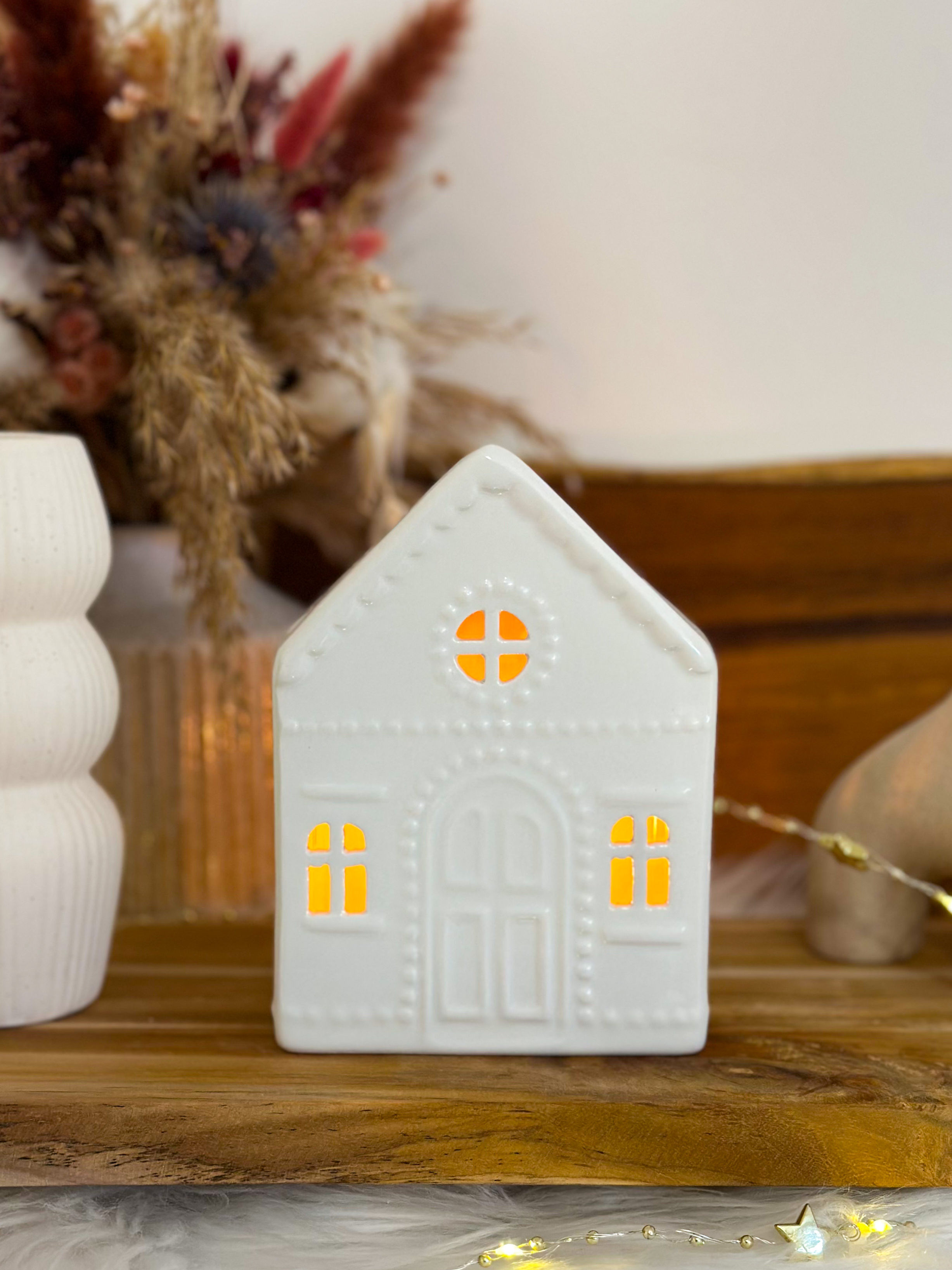 Décoration maison blanche lumineuse, fenêtres éclairées, sur étagère bois.