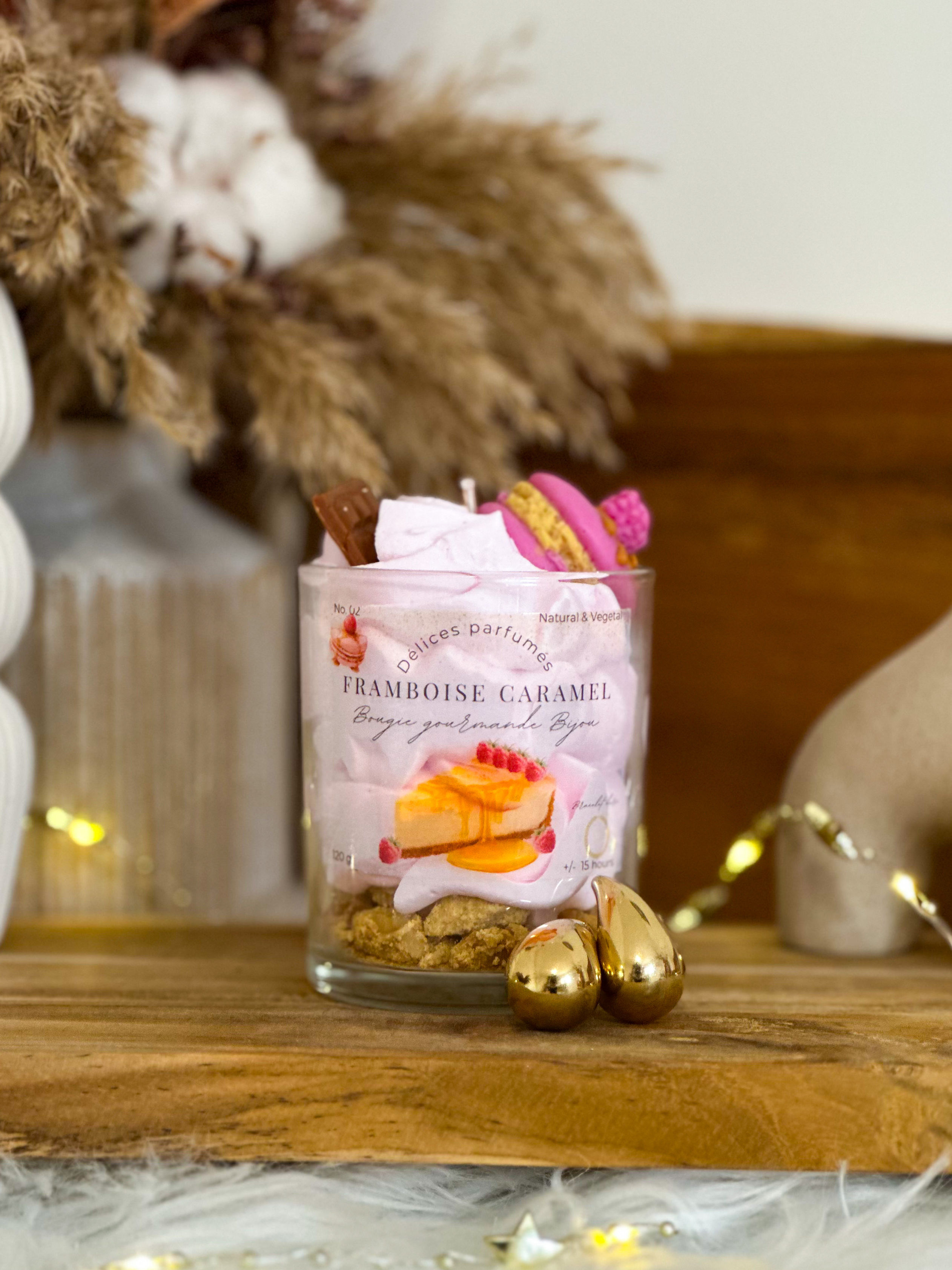 Bougie gourmande dans un pot sur planche en bois avec décorations dorées.