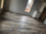 Modern rustic flooring and white doors in a room renovation.