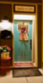 Teal apartment front door with patriotic gallery decor.