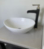 Modern bathroom vessel sink with matte black faucet.