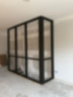 Modern black frame elevator enclosure under construction.