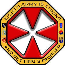 Red and gold military emblem with bold text: "Eighth Army Is Strong and Getting Stronger," conveying strength and unity.