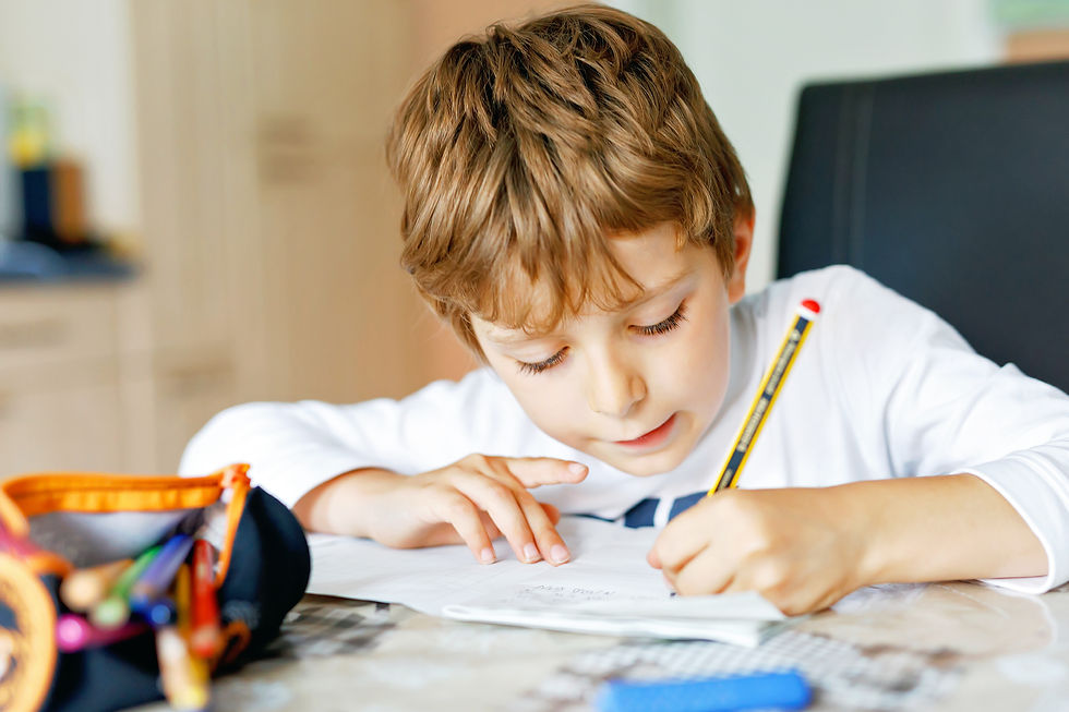 A child with brown hair writes intently at a table, using a yellow pencil. A colorful pencil case is nearby, creating a focused, studious mood.