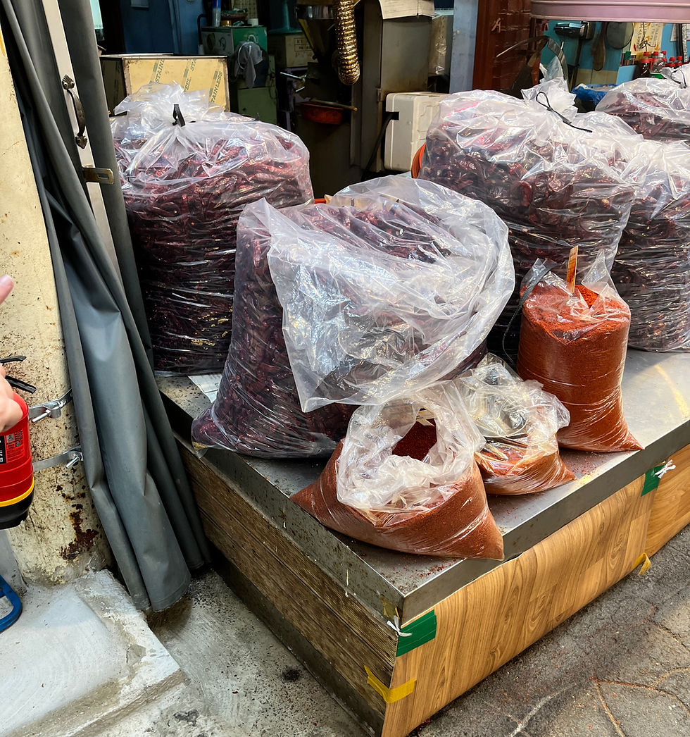 bags of red peppers and red pepper powder at a traditional korean market