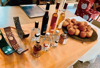 Bottles of assorted beverages and a plate of apples on a table with decorative trays. Warm lighting and a cozy, inviting atmosphere.