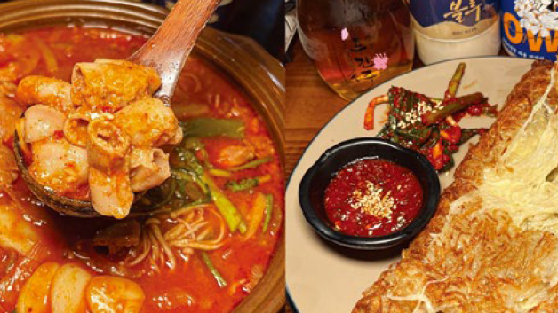 Spicy stew and fried dish on a table. Stew is red with seafood and vegetables. Fried dish is served with red sauce and drinks in background.
