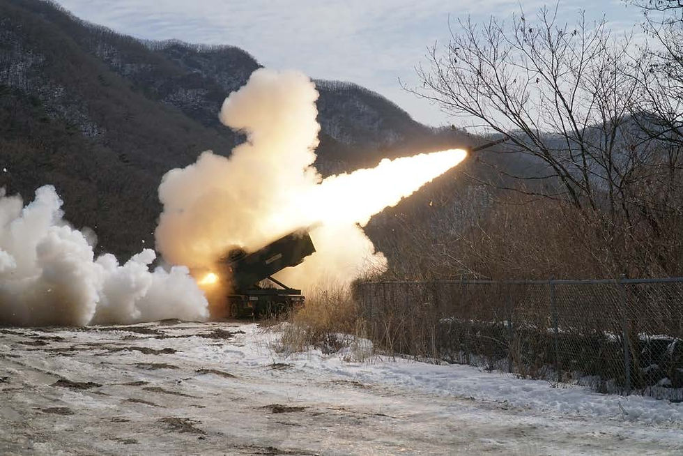 A military vehicle fires a missile, emitting smoke and flames, in a snowy, mountainous area with bare trees and overcast sky.