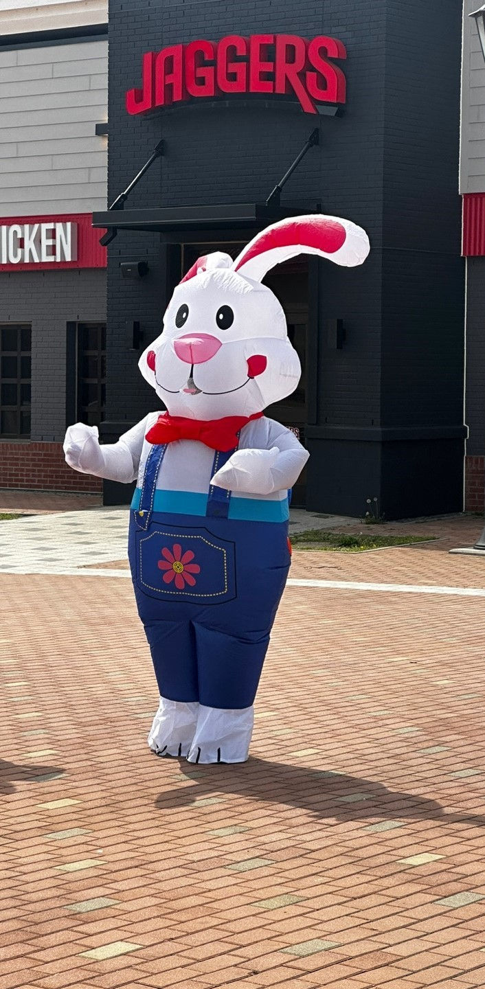 Inflatable rabbit in blue overalls stands outside a restaurant. Background features "JAGGERS" sign in red letters.