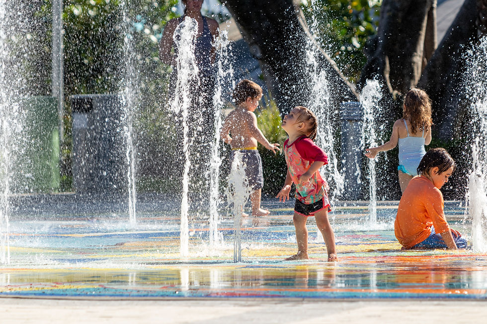 four children playing in a splash pad in the summer