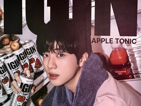 Person holding IGIN Apple Tonic can from fridge, surrounded by more cans. The word "IGIN" is prominent. Mood is casual and relaxed.